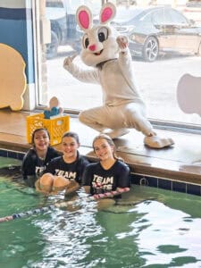 Booboo Bunny posing with Aqua-Tots North Richland Hills swim instructors during Easter celebration