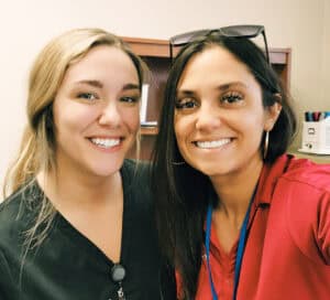 CommunityMed’s Carmen Enzweiler and Iza Maldonado smiling together at Shady Brook Career Day in Hurst