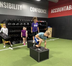 Kids navigating the mini obstacle course under Coach Lekieath’s encouragement
